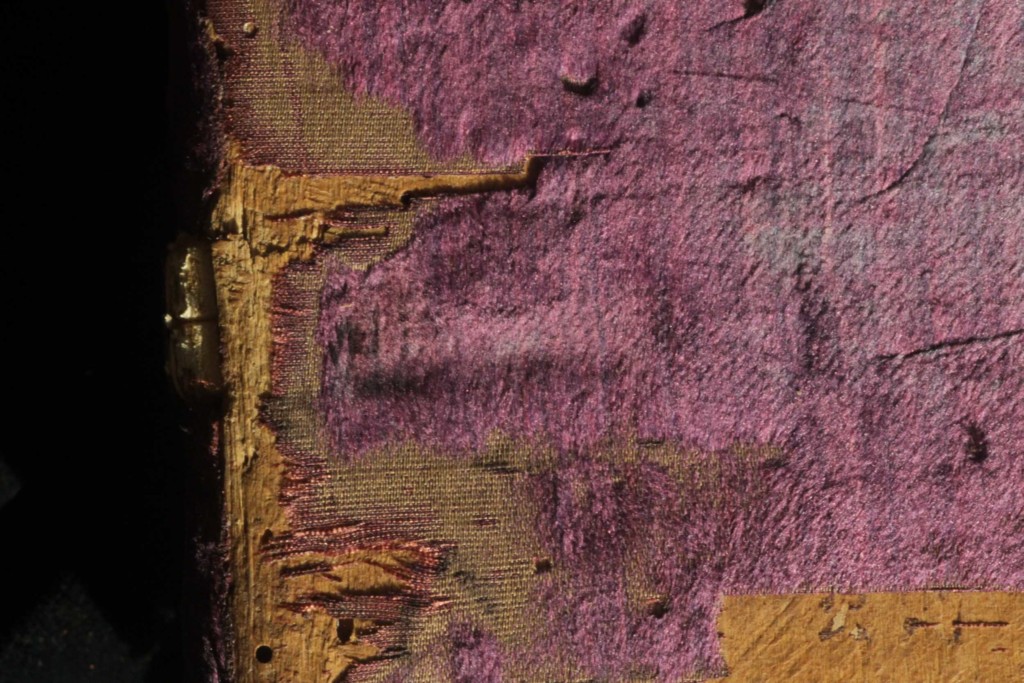 The contour of the sewing support recessed into the board is outlined on the velvet covering 